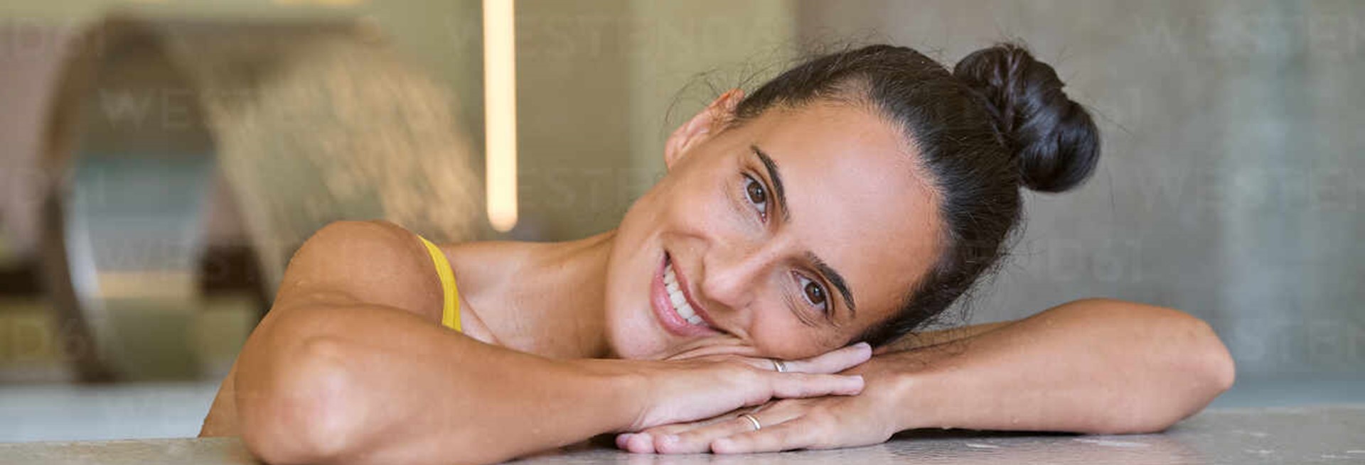 Happy Young Female Looking At Camera And Smiling While Relaxing During Spa Session With Hydro Massage In Modern Wellness Center ADSF16744
